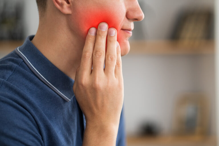 A man with toothache, periodontal disease in wisdom teeth, painful area highlighted in red