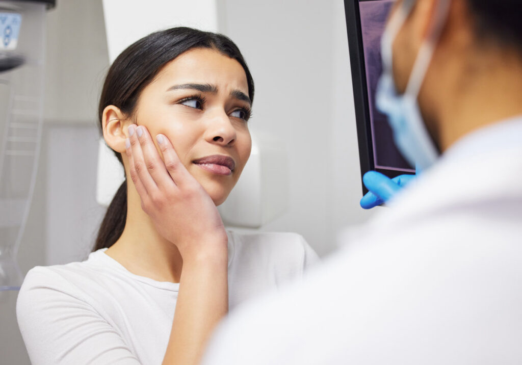 Toothache, dentist and woman in pain, clinic and consultation for dental health of patient in office. Appointment, person and listening to diagnosis of doctor, cavity and medical help for mouth.
