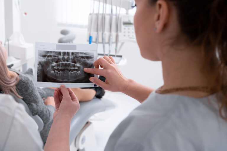 Female dentist reviewing a dental X-ray with a patient during a consultation