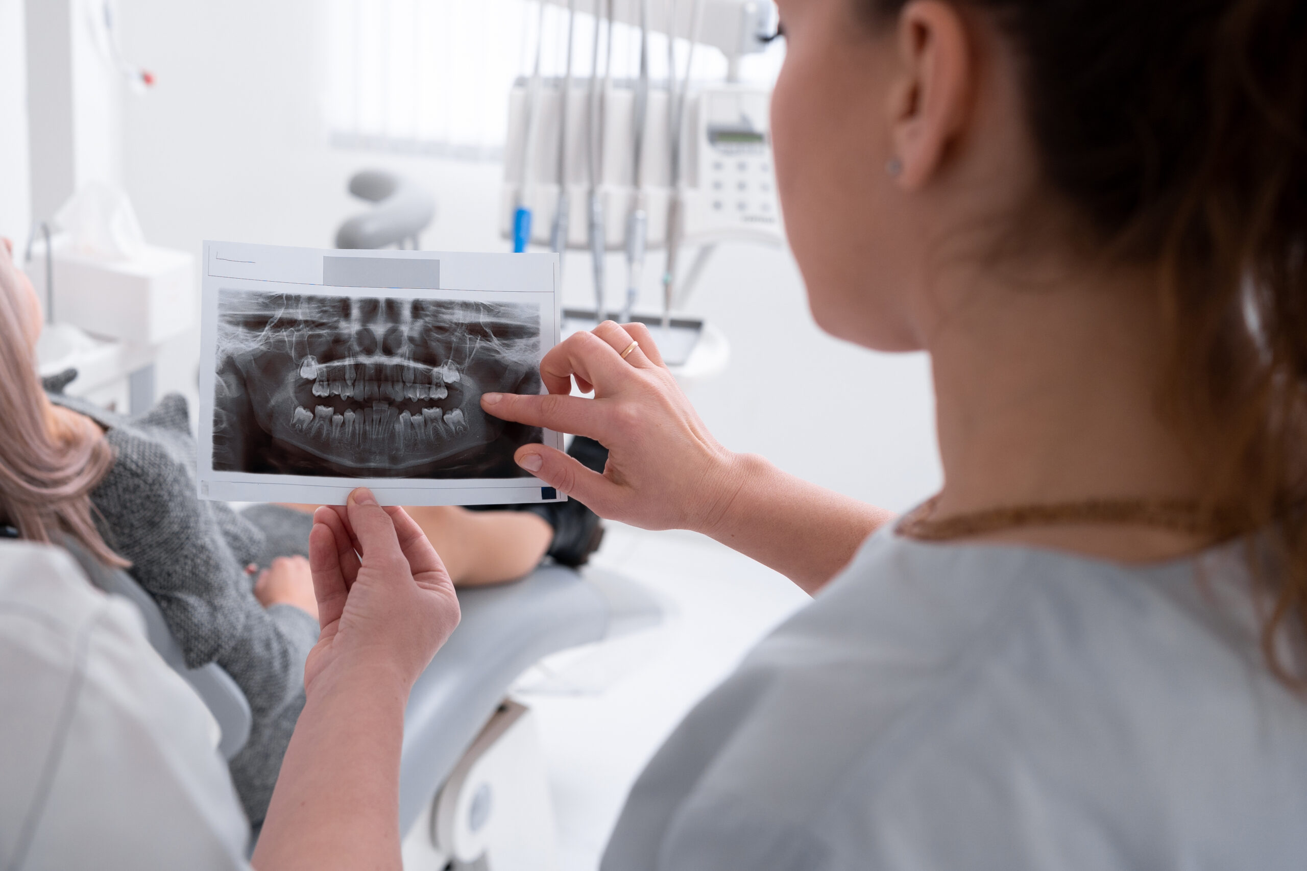 Female dentist reviewing a dental X-ray with a patient during a consultation