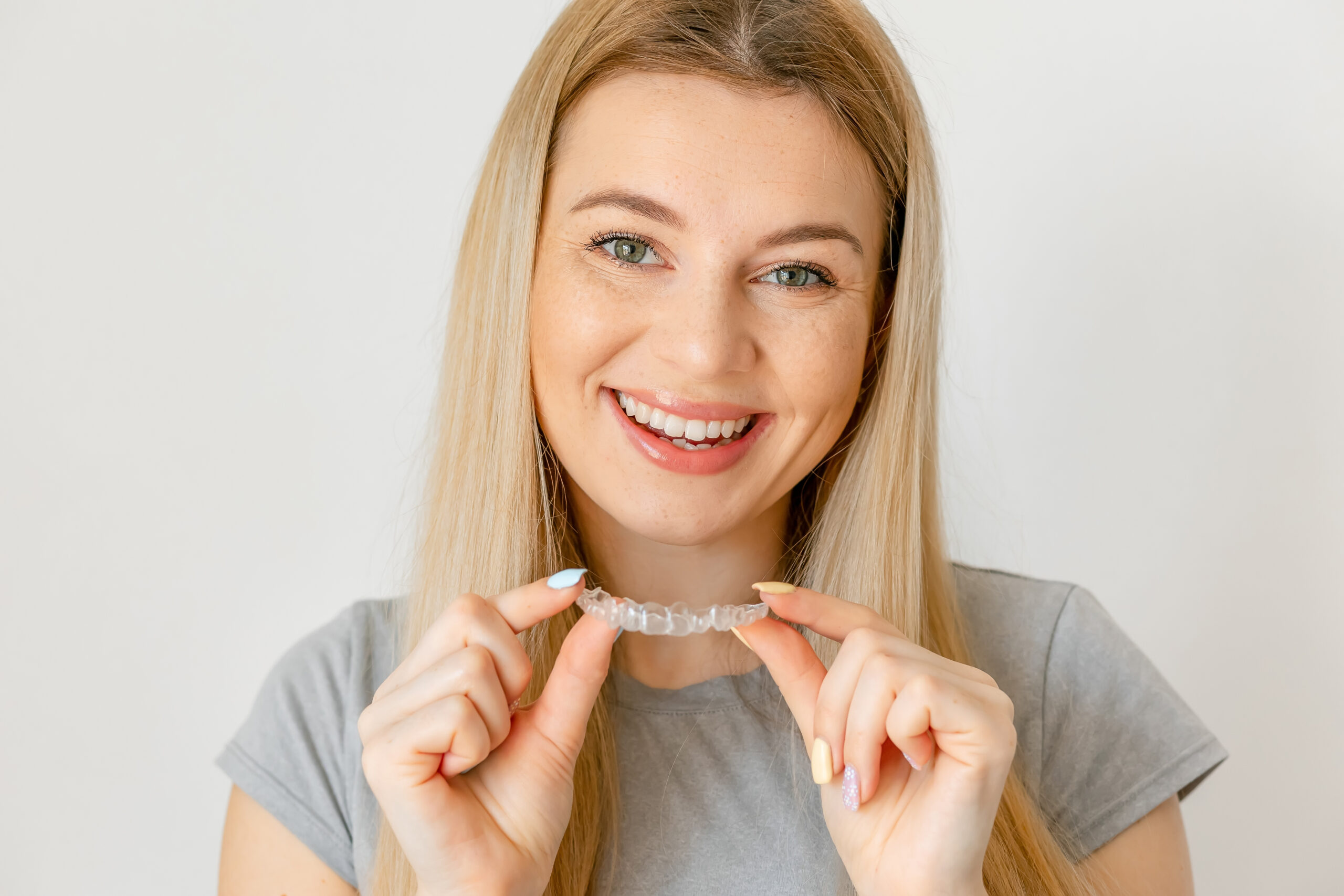 Joyful young woman undergoing clear-aligner treatment
